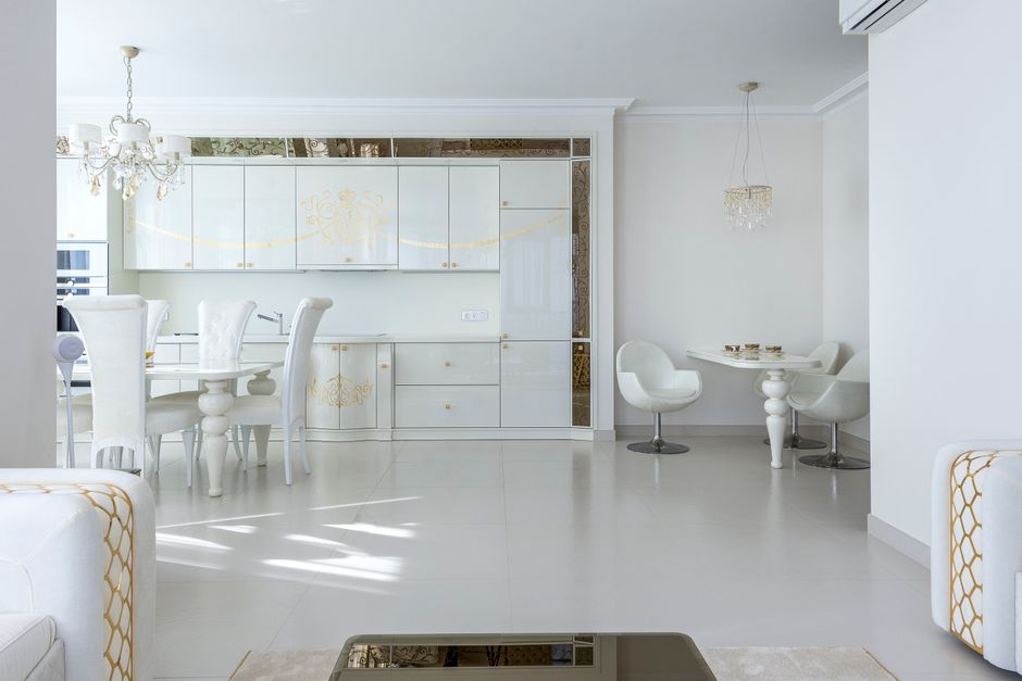 The interior of a bright and modern luxury kitchen, featuring high-end appliances, a clean marble island, and minimalist design, showcasing a key selling feature of a home.