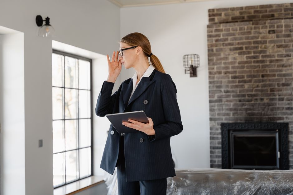 A professional and friendly real estate agent showing clients an accurate home listing on a tablet, representing the solution of using a direct MLS data feed.
