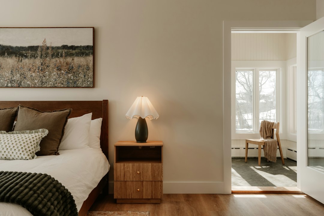 A thoughtfully curated welcome basket with local products sits on a perfectly made bed in a sunny, inviting guest room, showcasing a personalized guest experience beyond a typical platform booking.